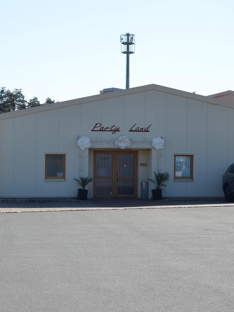 Die Eventhalle Partyland von außen mit dem Parkplatz direkt vor dem Eingang